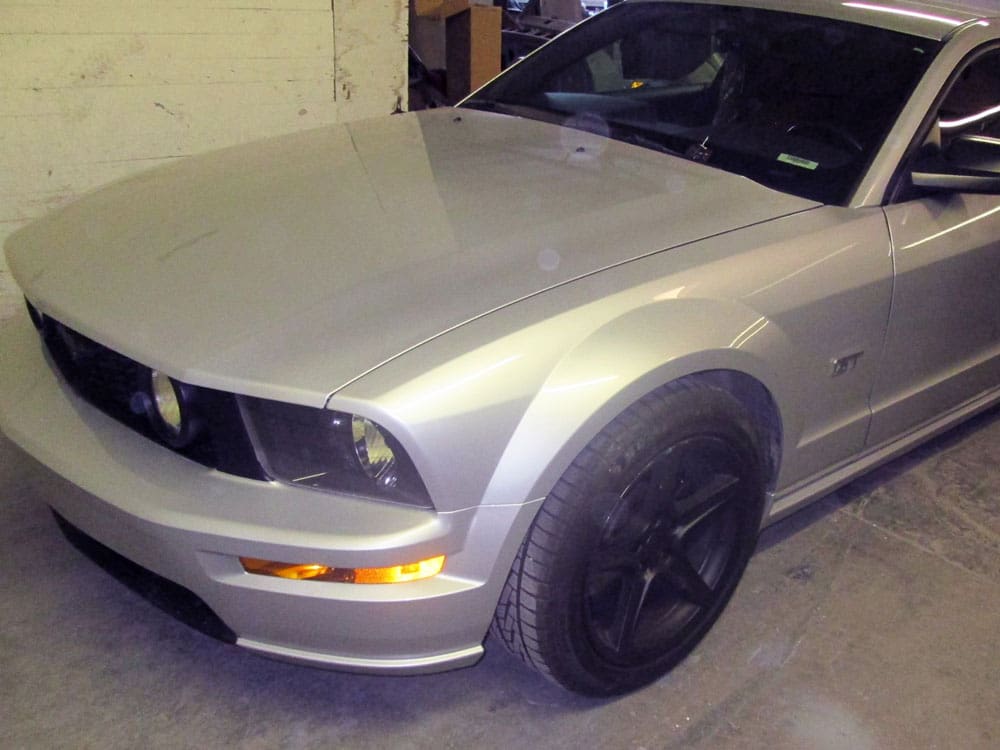 Pristine silver Ford Mustang after fender repair, looking restored