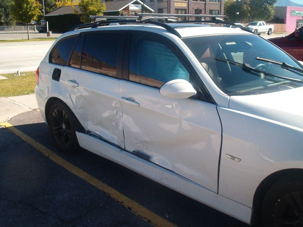 White BMW wagon with extensive side collision damage